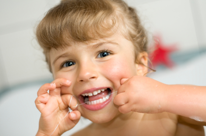 Cute little girl trying to floss- image from istockphoto