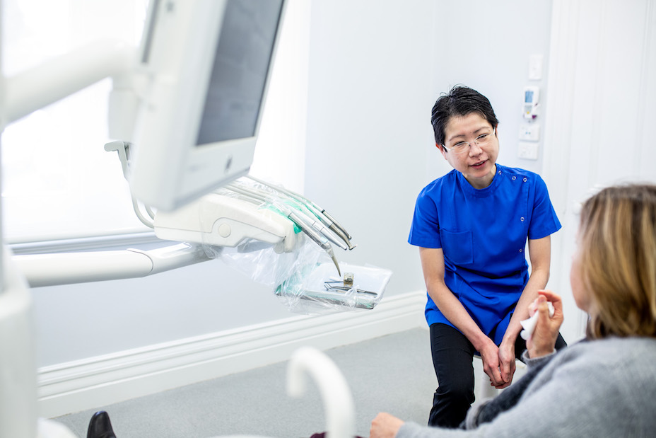 Dr Ailin Teo, dentist, pictured at chairside reassuring a nervous patient