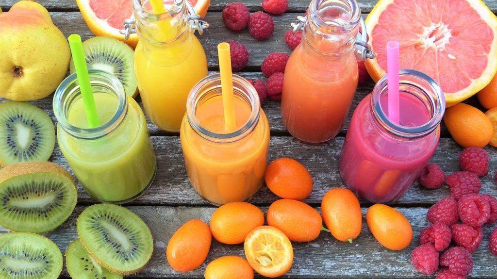 A colourful display of fruit smoothies and fresh fruit