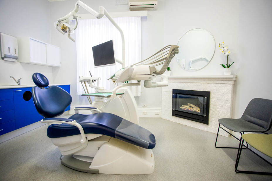 Treatment room for the provision of general dentistry. It features a dark blue chair and other quality instruments against a beautiful decor.